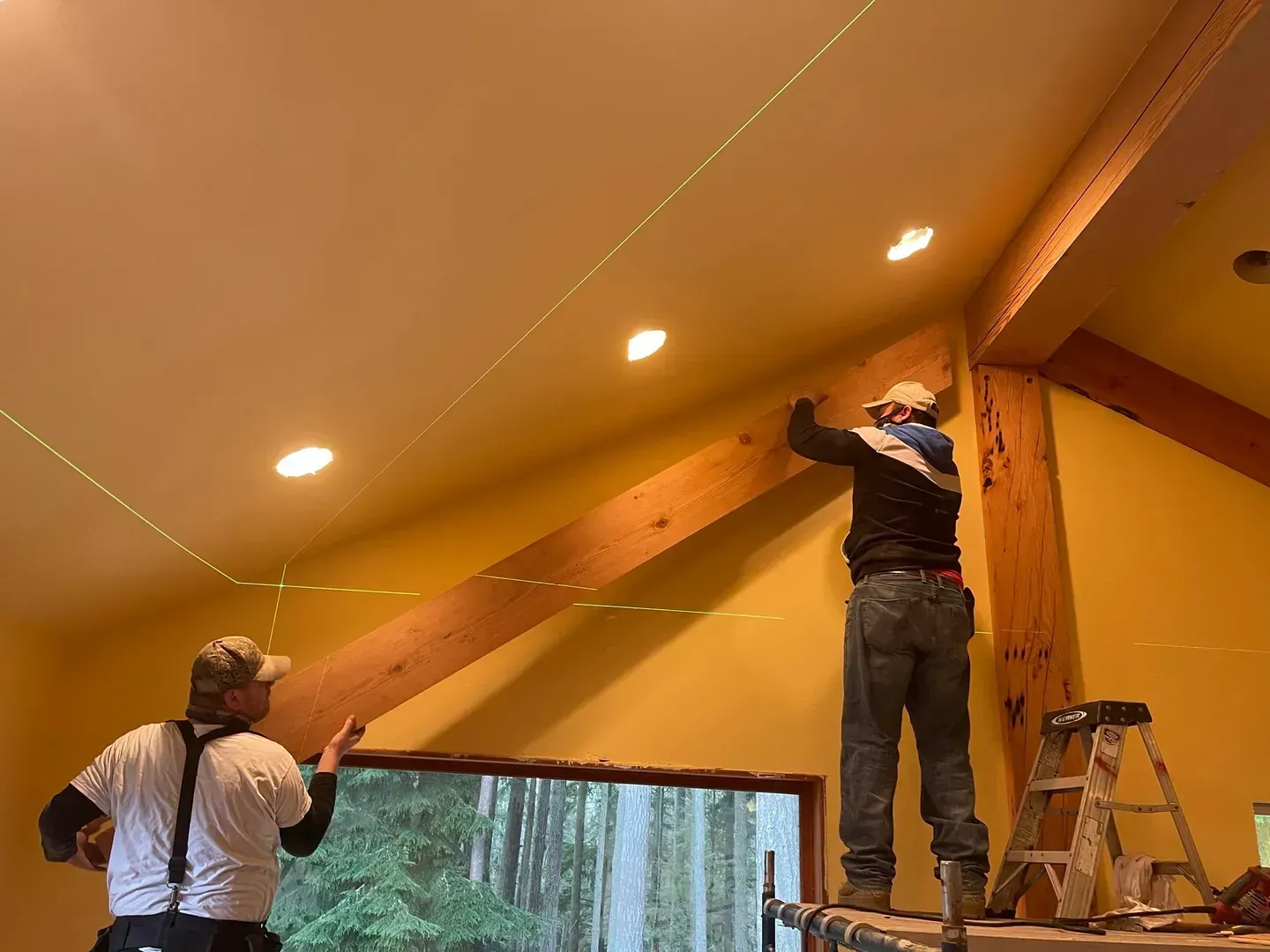 Two carpenters setting a beam in a vaulted ceiling