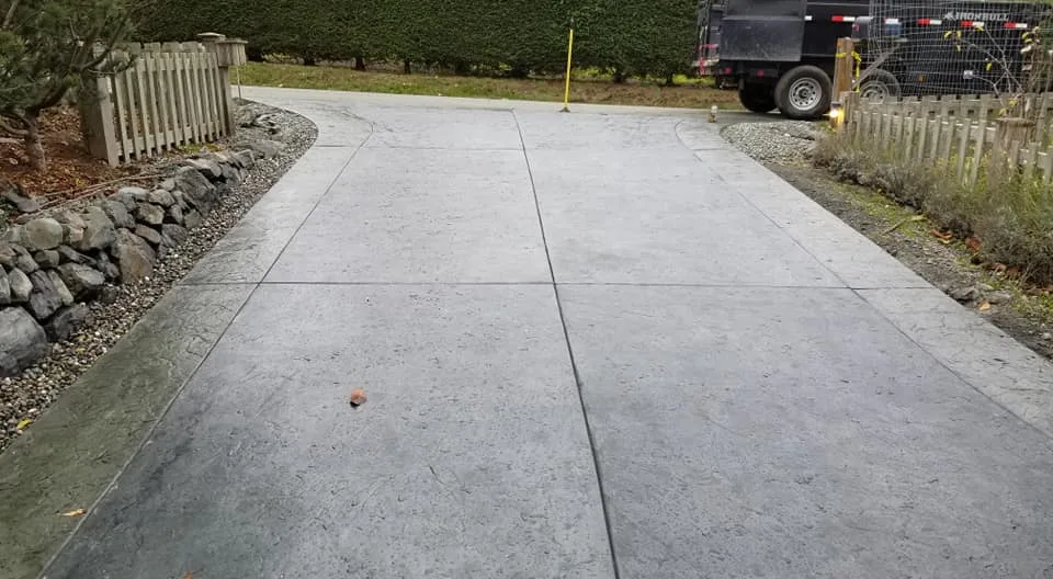 New concrete driveway with a dump trailer at the end