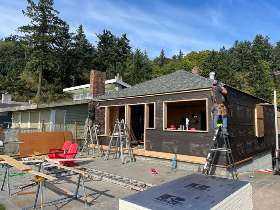 Cottage walls sheathed and wrapped with new door and window openings framed