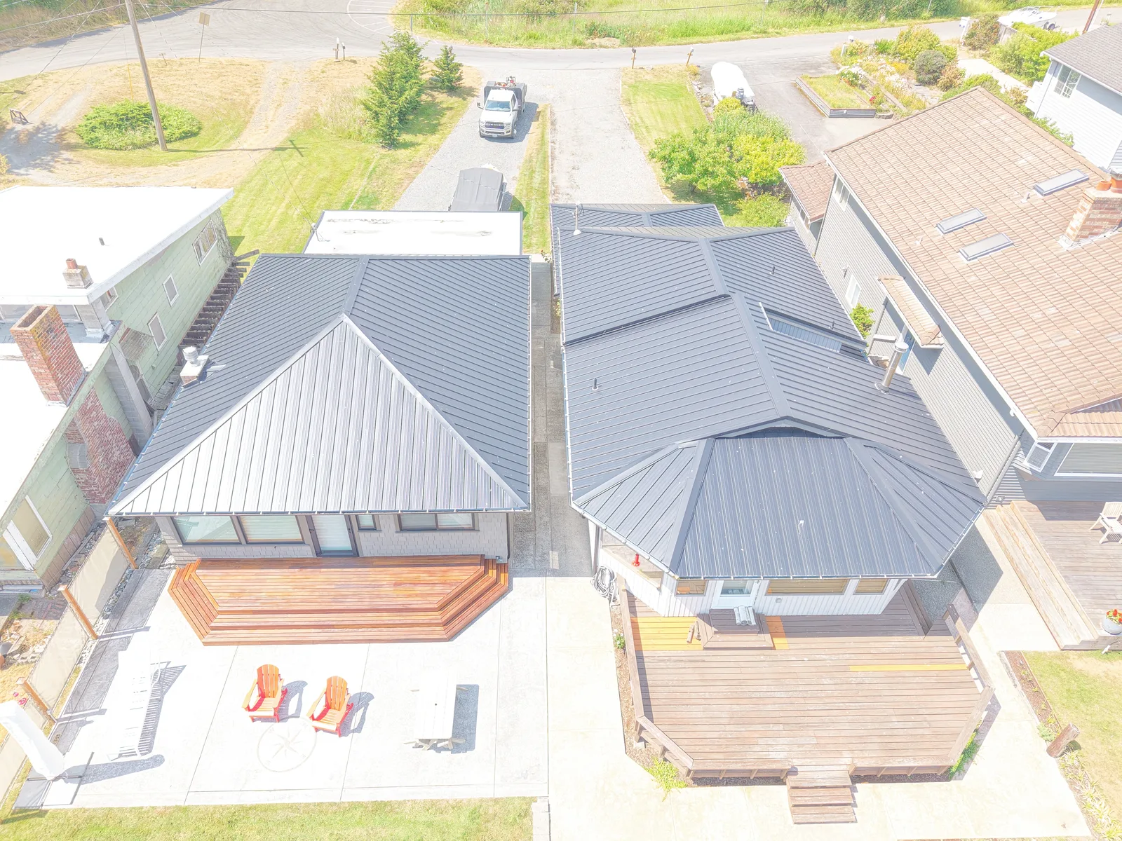 Aerial view of a custom home with a standing seam metal roof and covered patio