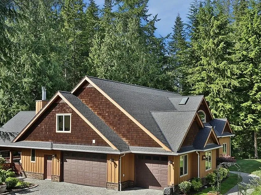 Garage side of a custom home with cedar shingle gables and board-and-batten siding