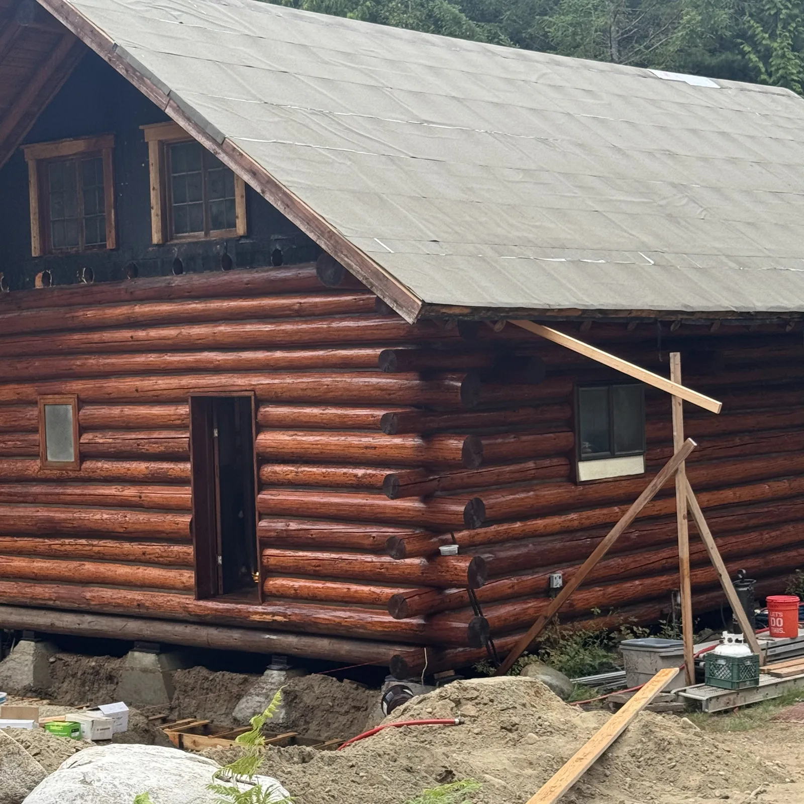 Log home with new roof framing and underlayment going on during construction