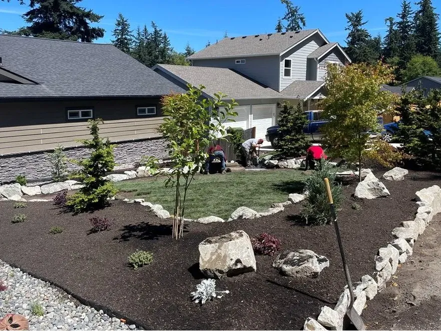 New planting beds with boulders and a rock border in a front yard