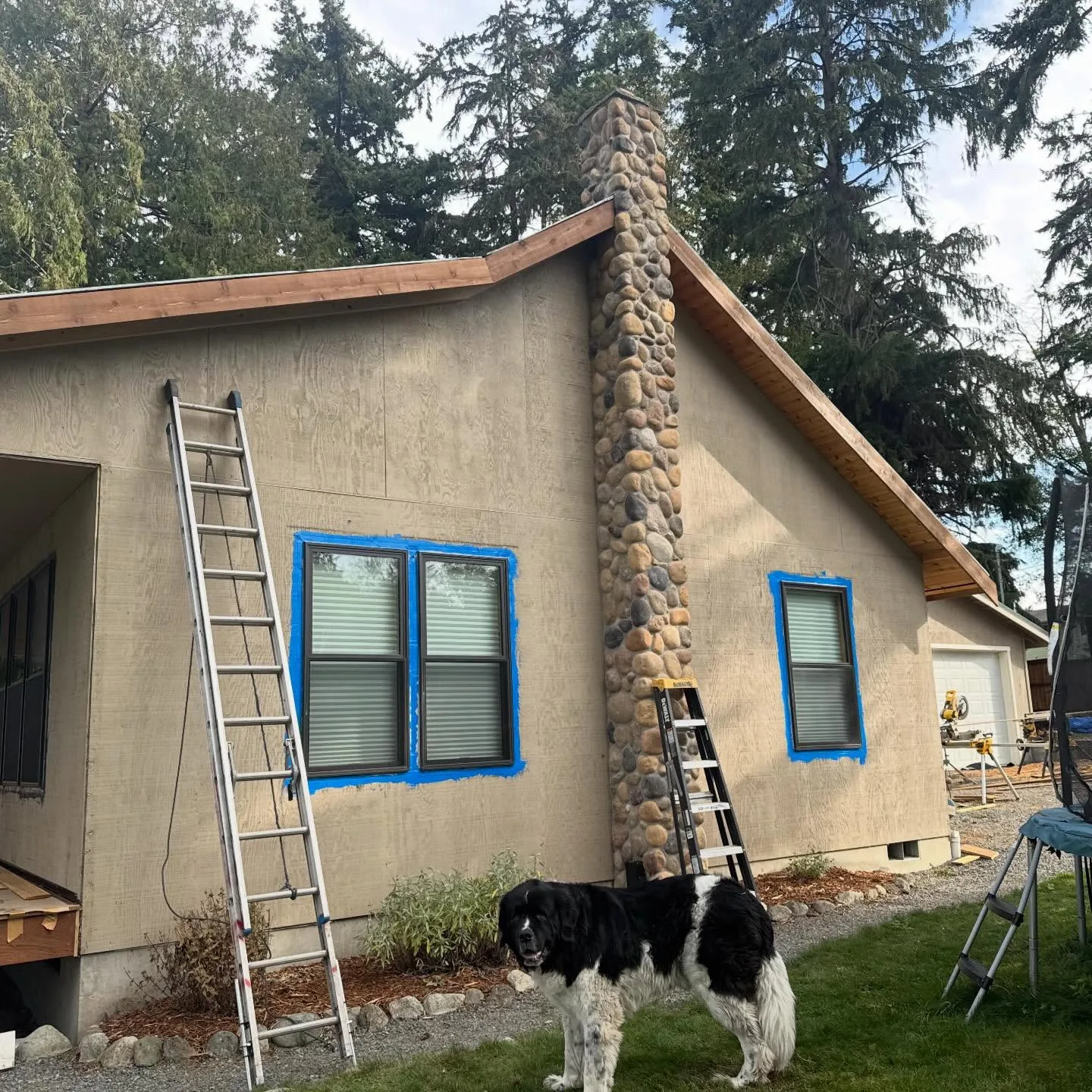 Stucco house with the windows taped off before its cedar shingle siding remodel