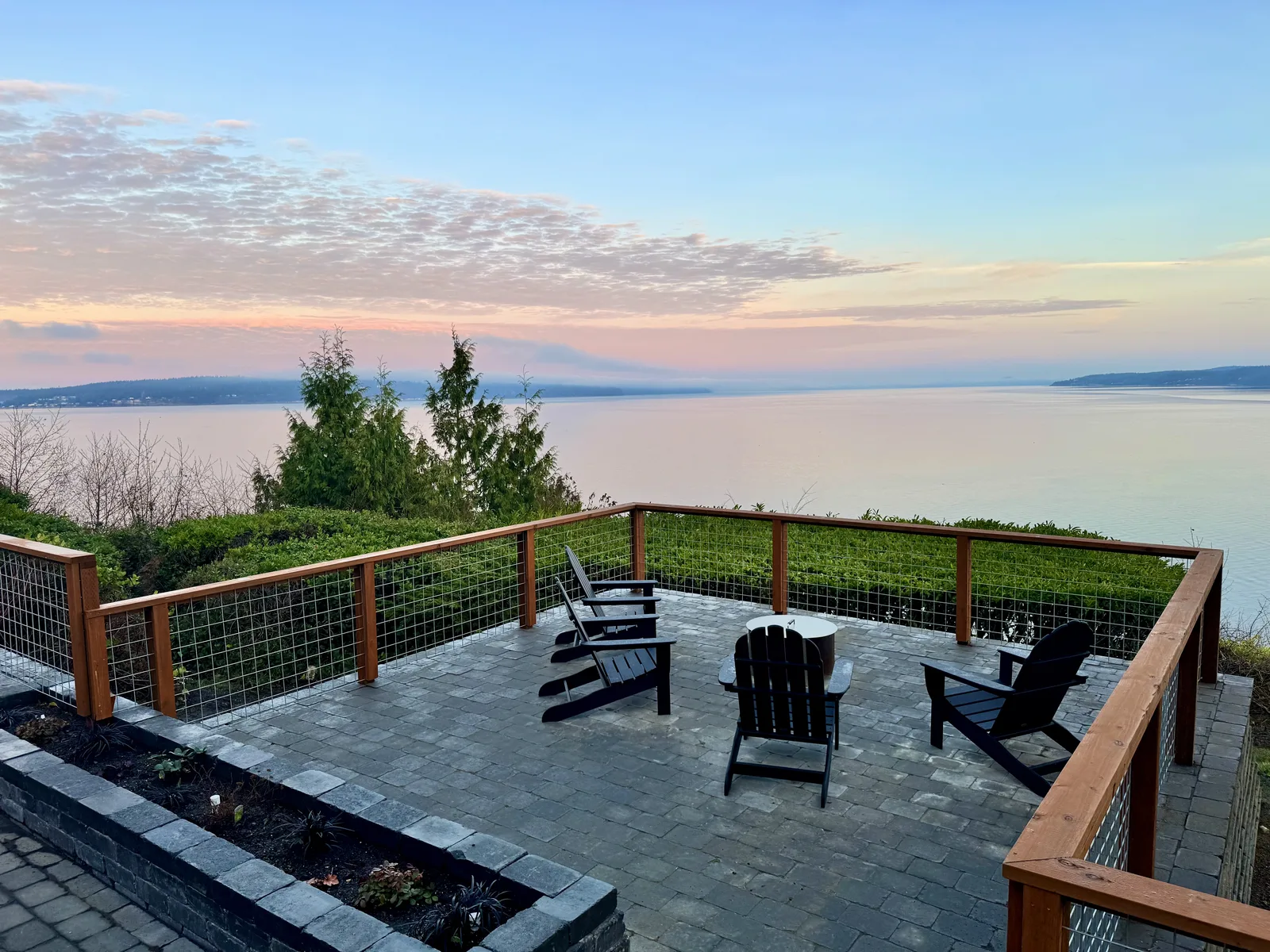 Waterfront paver patio and cable-rail deck at sunset on Whidbey Island